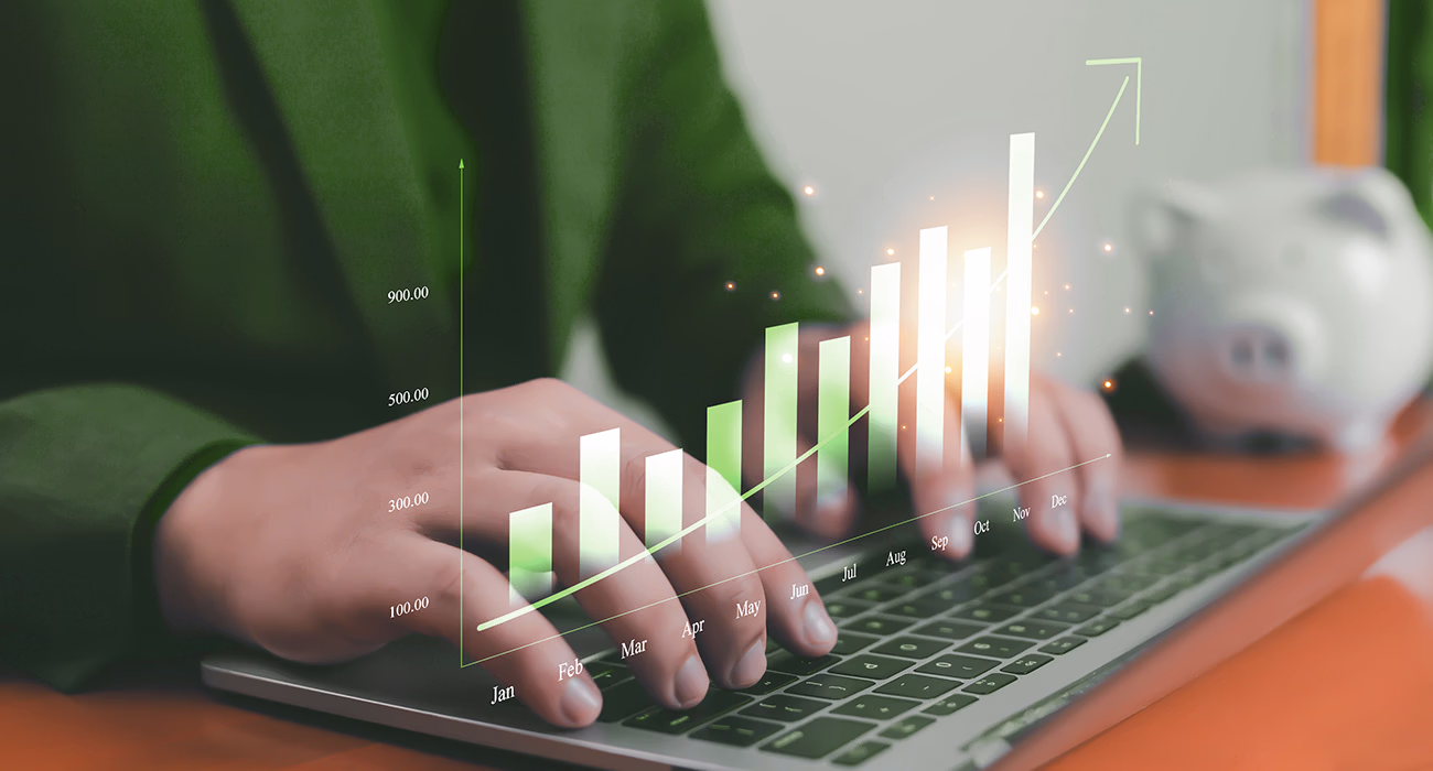 Business growth and financial planning concept with a person analyzing rising bar chart on laptop