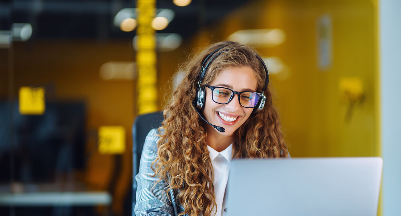 Call center agent with headset working on support hotline in modern office